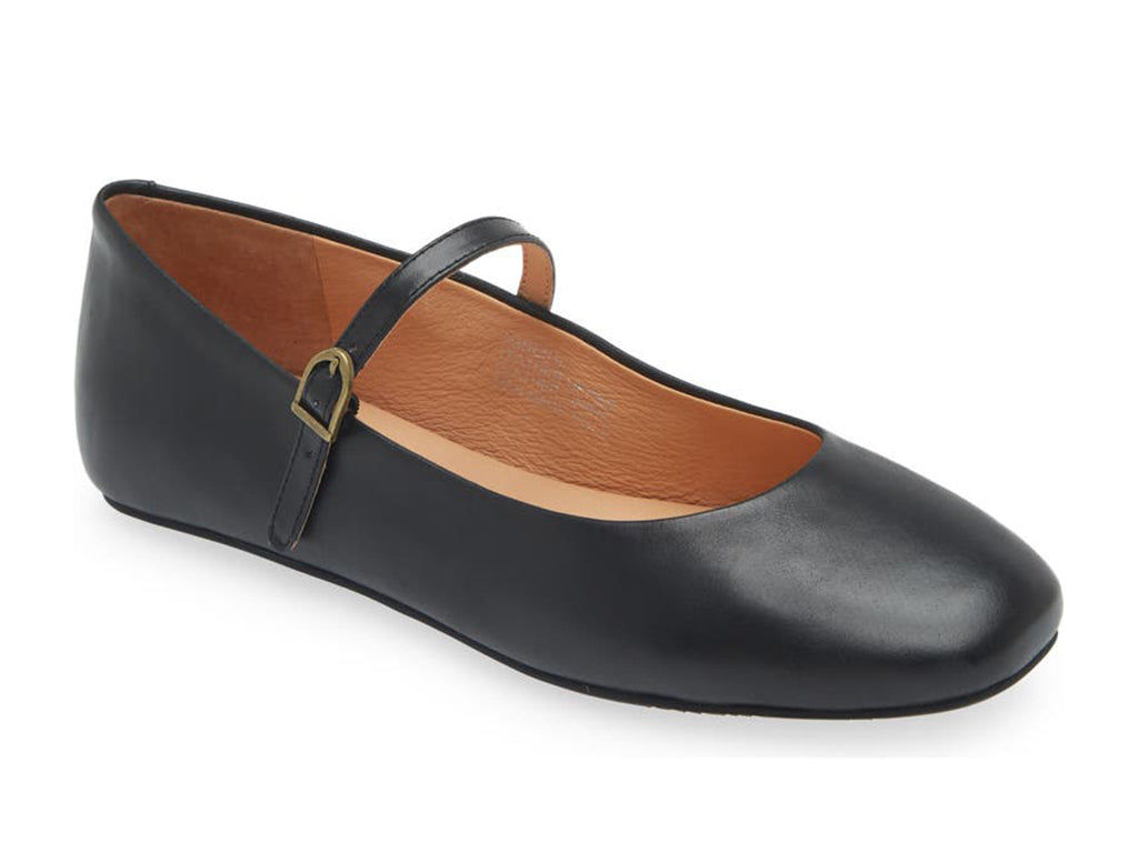 Black leather rounded toe flat with over the instep buckle strap on a white background side angle view