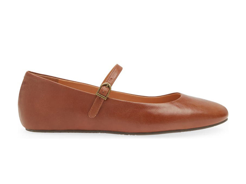 Brown leather rounded toe flat with over the instep buckle strap on a white background side view