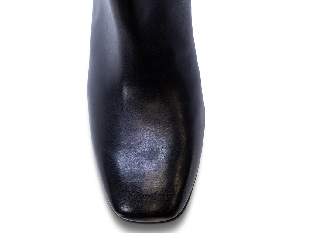 A black leather ankle boot with a square toe, a block heel, and a wide strap with a rectangular buckle - view of the toe shape
