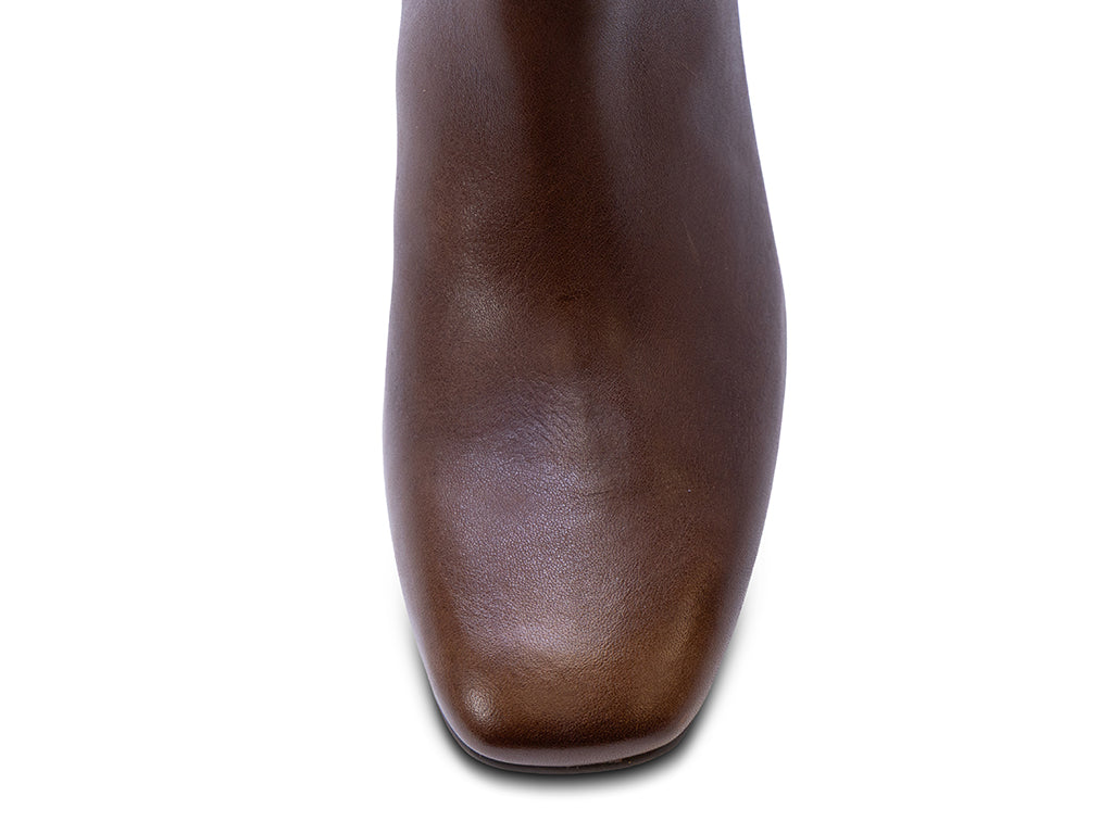 A brown leather ankle boot with a square toe, a block heel, and a wide strap with a rectangular buckle - view of the toe shape