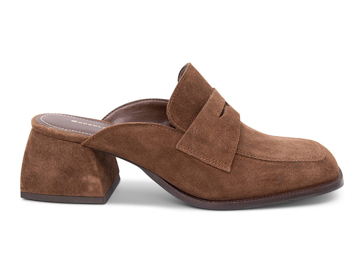 Brown suede slide shoe with a block heel and penny loafer design on a white background side view