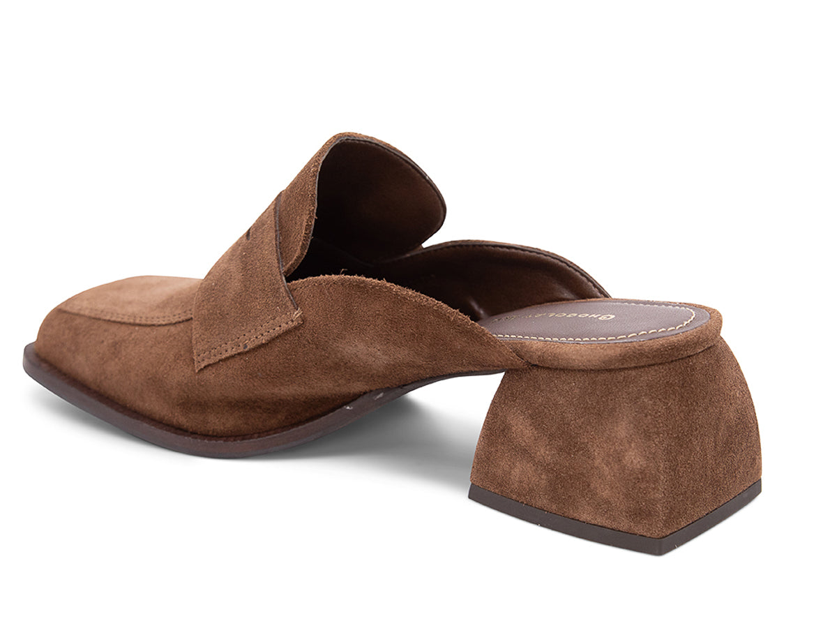 Brown suede slide shoe with a block heel and penny loafer design on a white background side angle view
