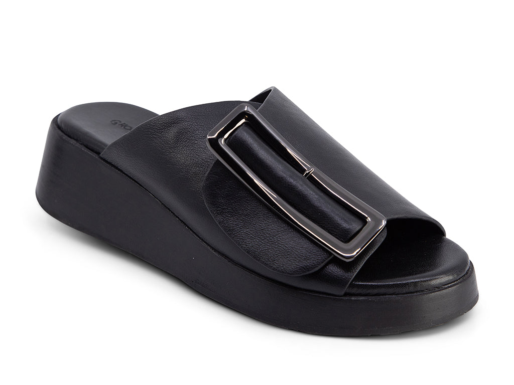 black wedge slide sandal with an oversized silver buckle