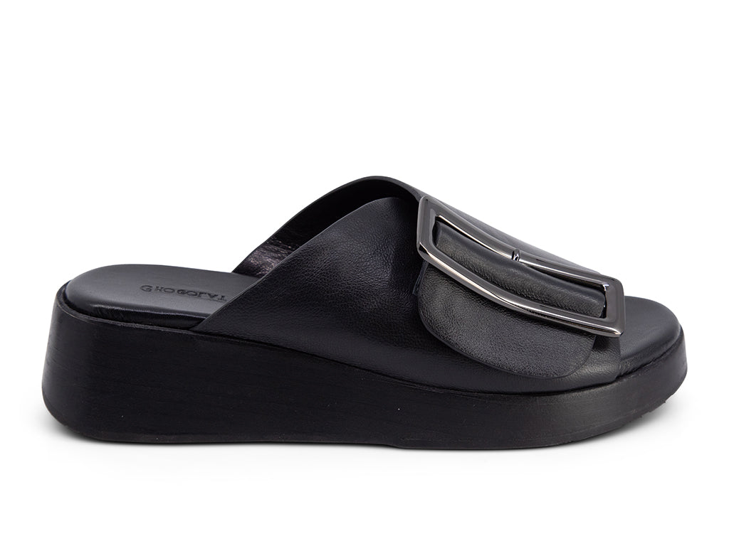 black wedge slide sandal with an oversized silver buckle - side view
