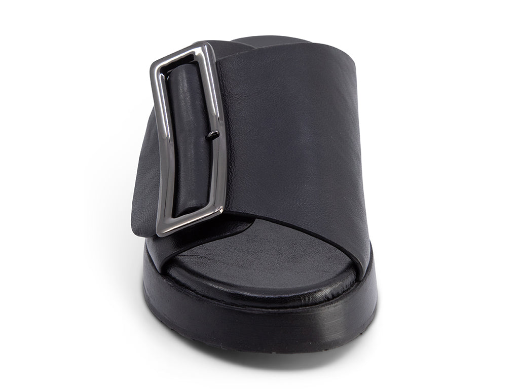 black wedge slide sandal with an oversized silver buckle - front view