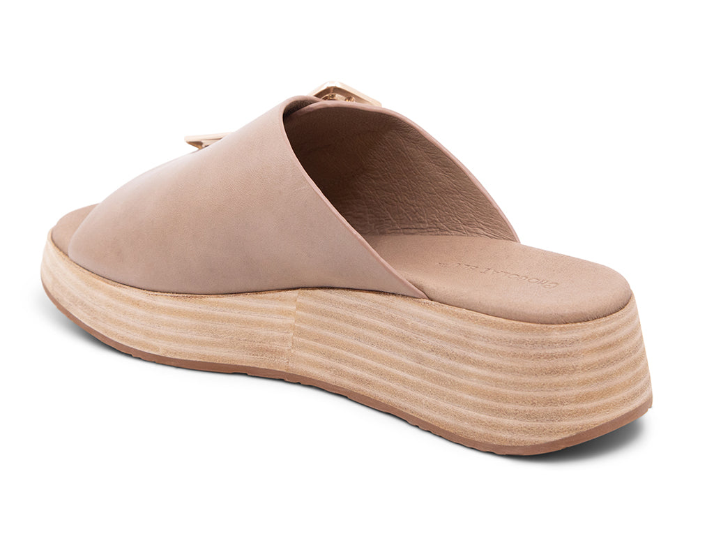 light khaki colored wedge slide sandal with oversized buckle - back angle view