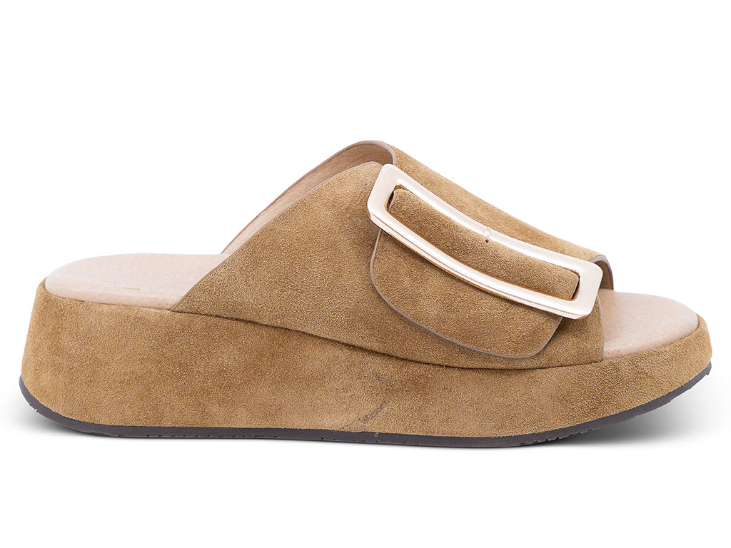 a camel suede wedge slide sandal with a wide strap and an oversized buckle - lateral side view