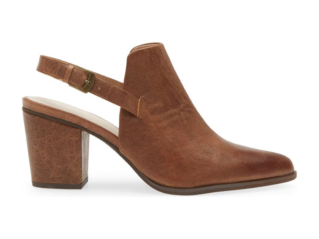 Brown pointed toe shoe with block heel and buckle ankle back strap on a white background side view