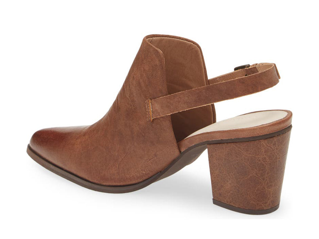 Brown pointed toe shoe with block heel and buckle ankle back strap on a white background side angle view