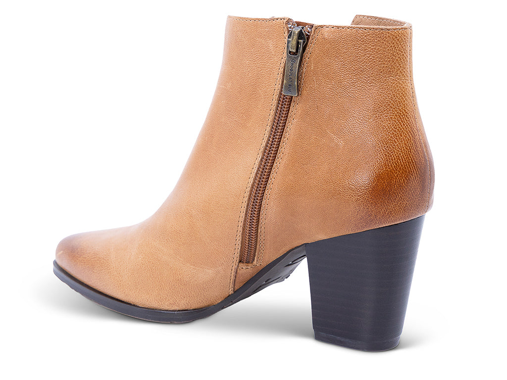 A caramel leather ankle boot with a side zipper and a dark block heel - medial side view