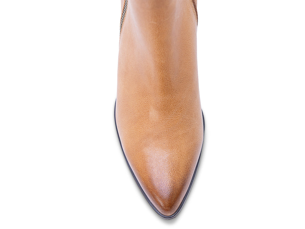 A caramel leather ankle boot with a side zipper and a dark block heel - view of the toe shape