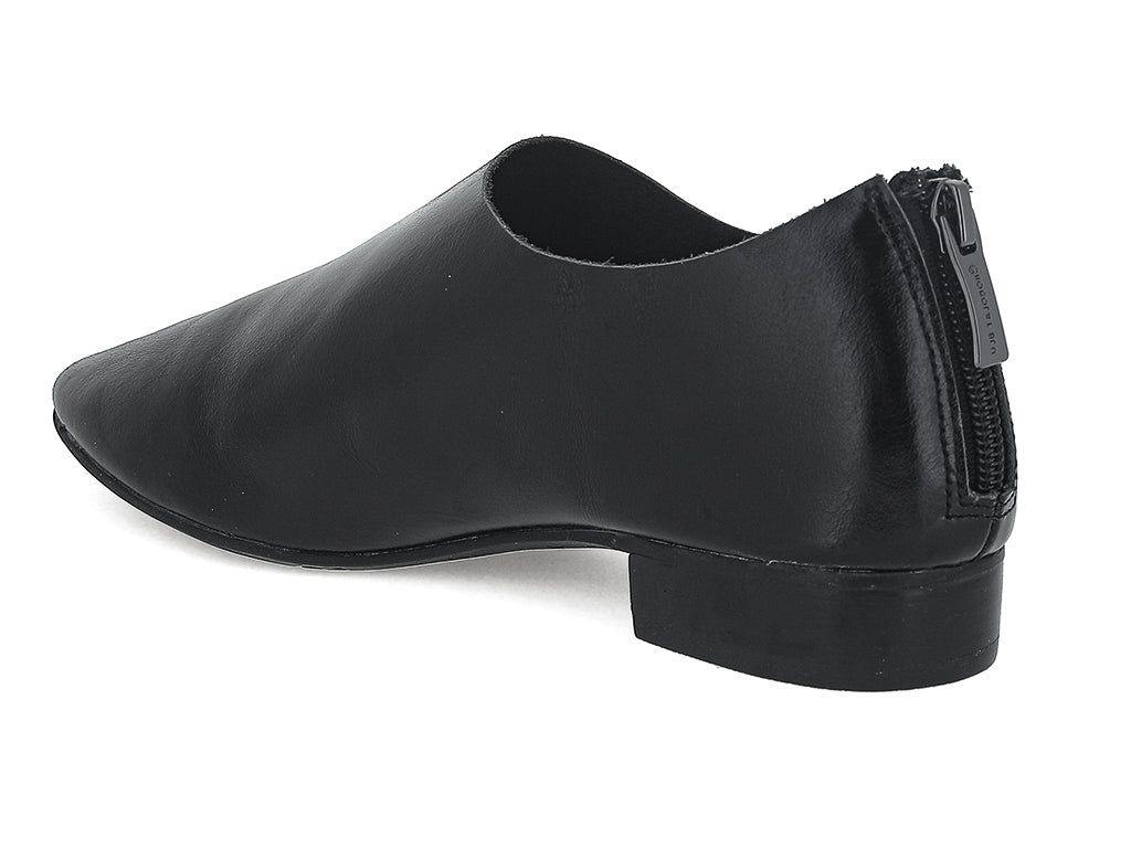 Black leather pointed toe flat with mini block heel and back zipper on a white background side angle view