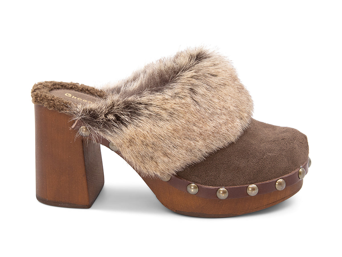 Brown heeled clog shoe with fur trim and grommet studs  on a white background side view