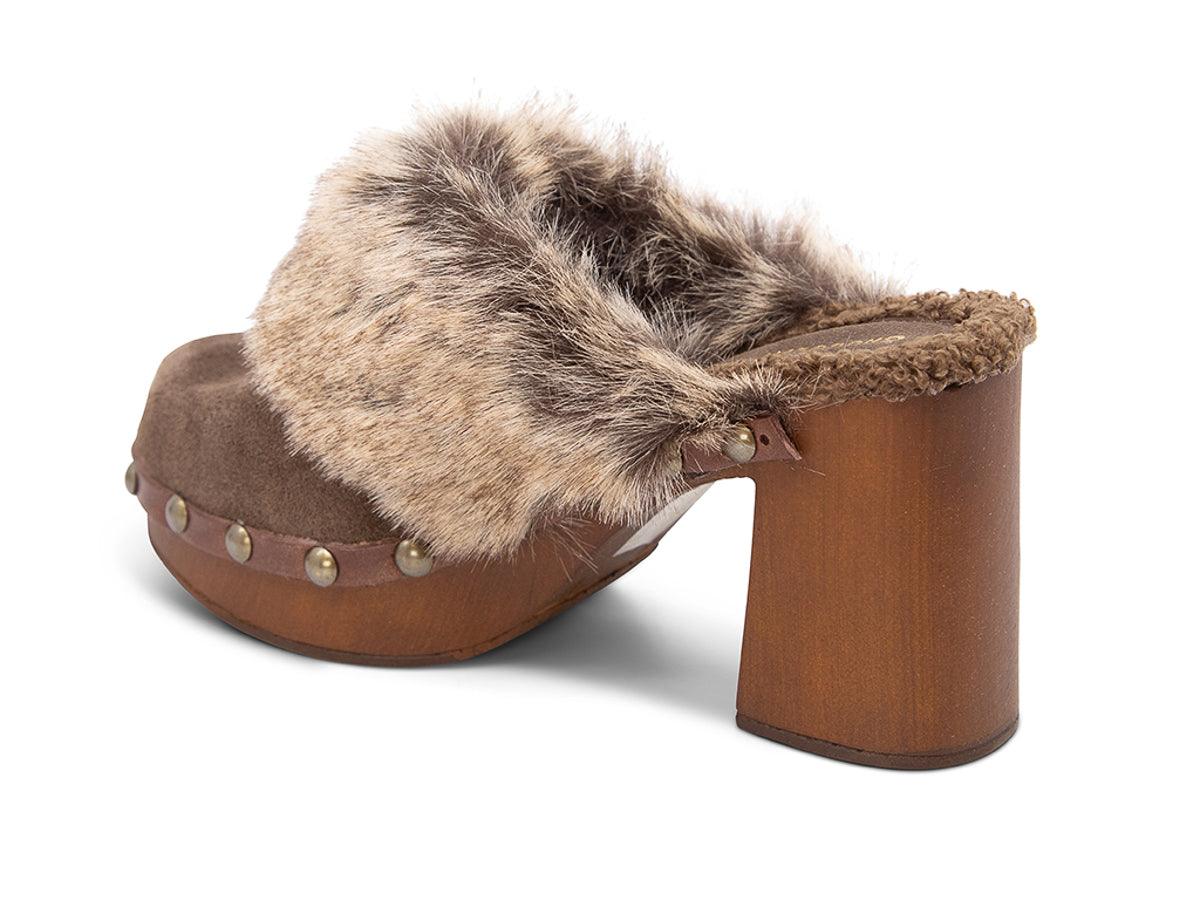 Brown heeled clog shoe with fur trim and grommet studs on a white background side angle view
