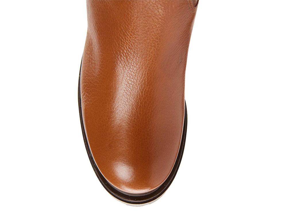 Brown pull-on knee-high boot on a white background top view