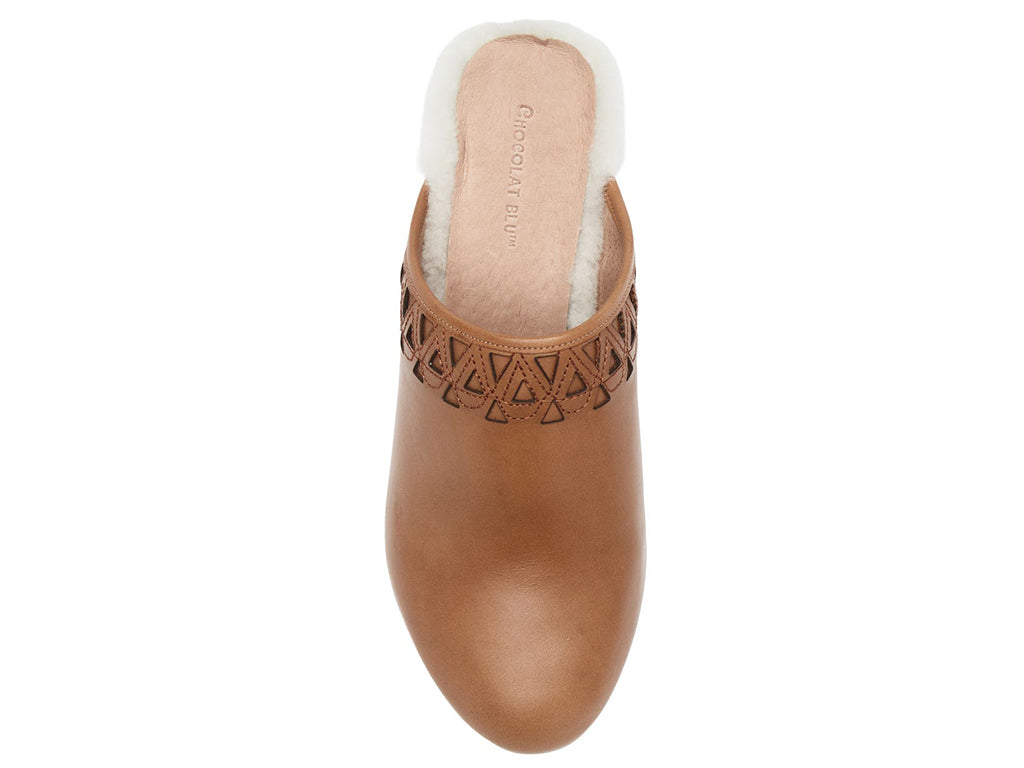 Brown heeled clog shoe with decorative cutout on upper and fur trim mid sole on a white background top view