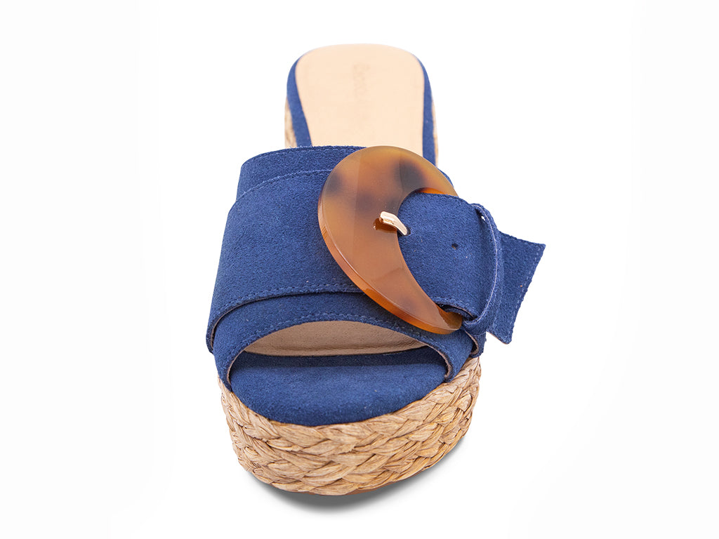 blue suede sandal with a moon shaped buckle on a raffia wrapped platform - front view