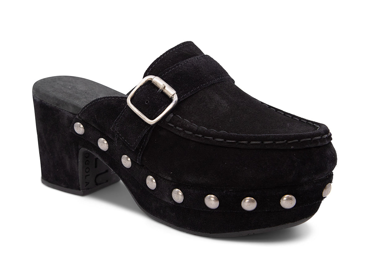 Black suede slide in block heel clog shoe with a decorative strap buckle and grommet studson a white background side angle view 