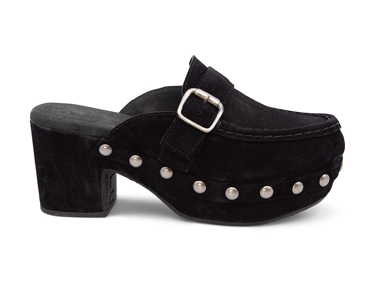 Black suede slide in block heel clog shoe with a decorative strap buckle and grommet studson a white background side view 