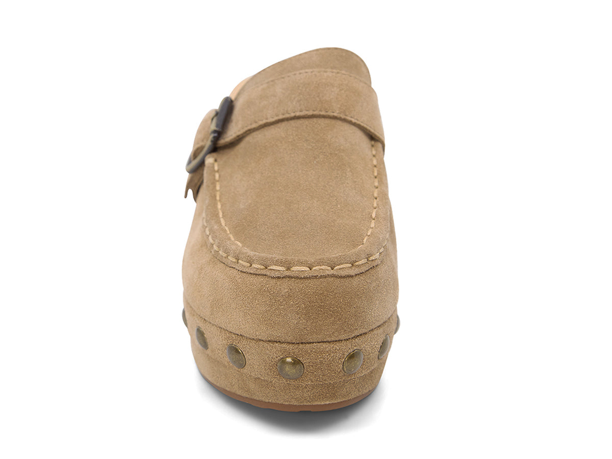 Camel suede slide in block heel clog shoe with a decorative strap buckle and grommet studson a white background front view 
