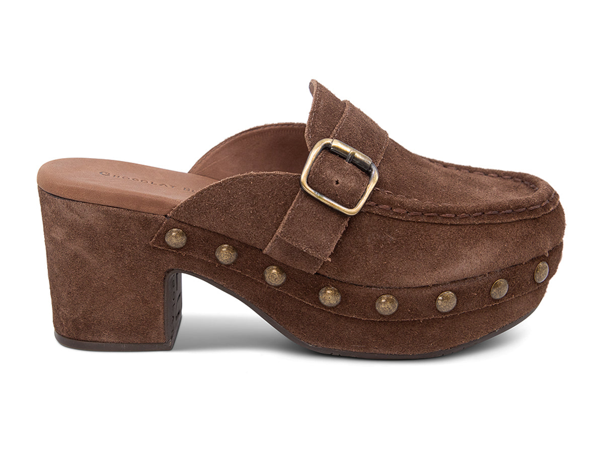 Chocolate suede slide in block heel clog shoe with a decorative strap buckle and grommet studson a white background side view 