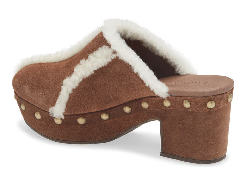 Brown suede platform heeled clog with white fur lining and gold studs on a white background side angle view