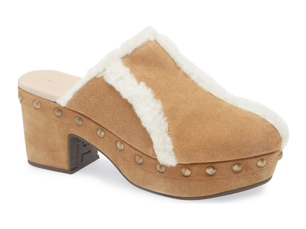 Tan suede platform heeled clog with white fur lining and gold studs on a white background side angle view