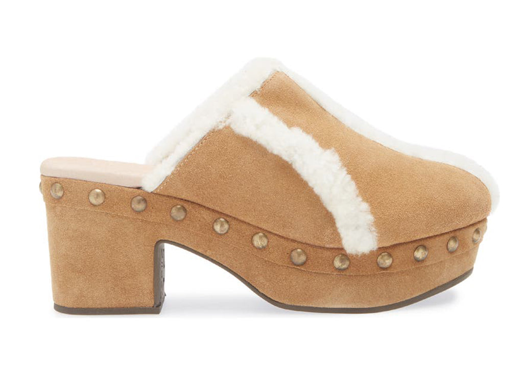 Tan suede platform heeled clog with white fur lining and gold studs on a white background side view