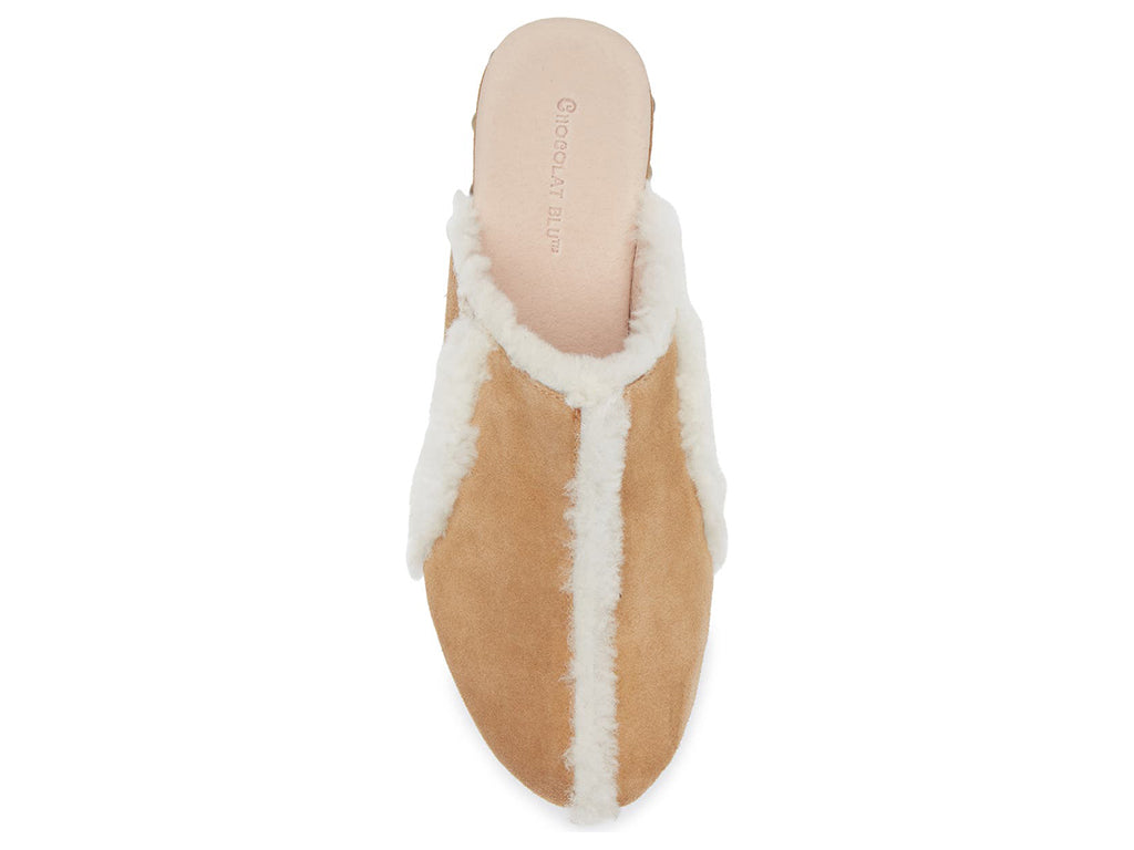 Tan suede platform heeled clog with white fur lining and gold studs on a white background top view