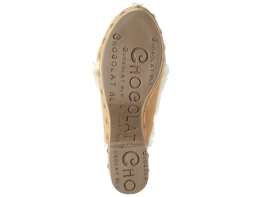 Tan suede platform heeled clog with white fur lining and gold studs on a white background bottom sole view
