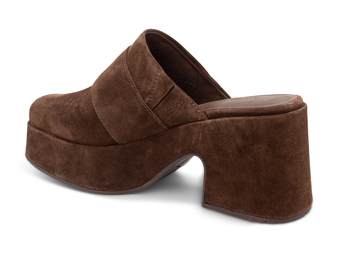 Brown suede platform slide in block heeled clog with gold buckle on a white background side angle view