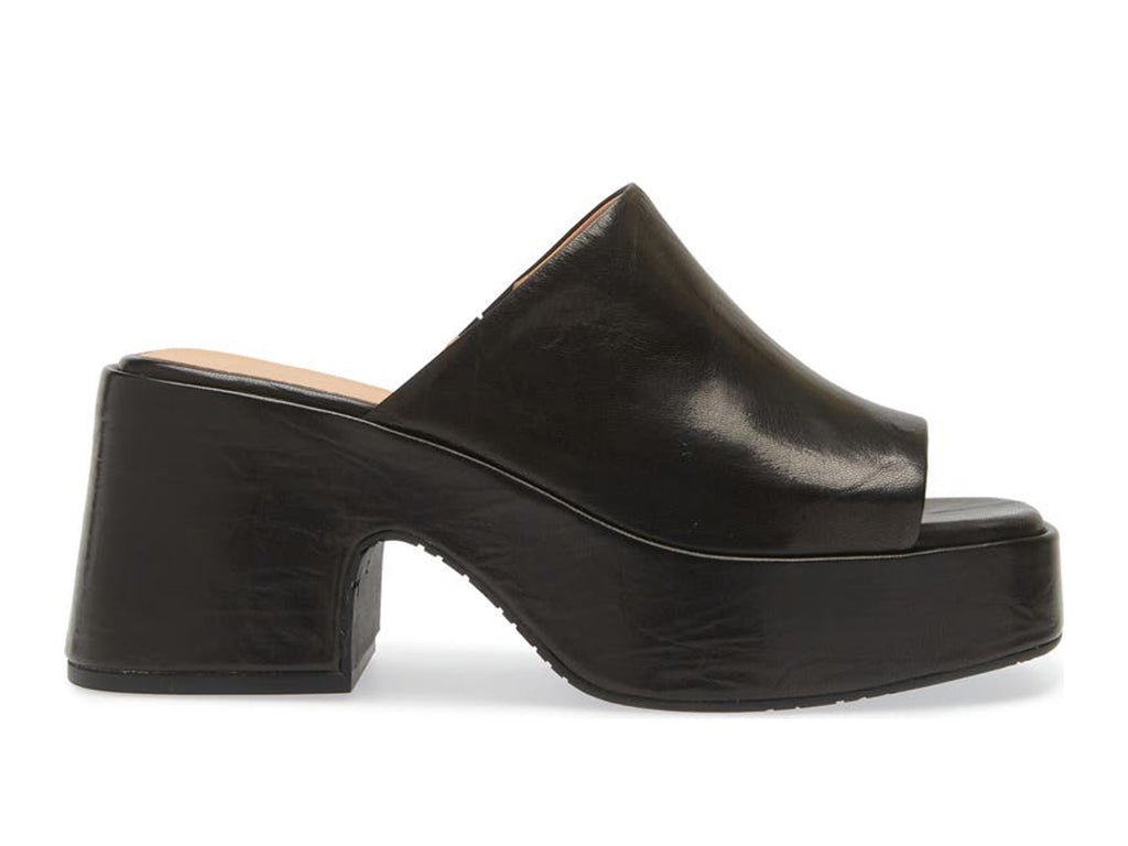 Black chunky heeled open toed platform mule with a leather upper on a white background side view