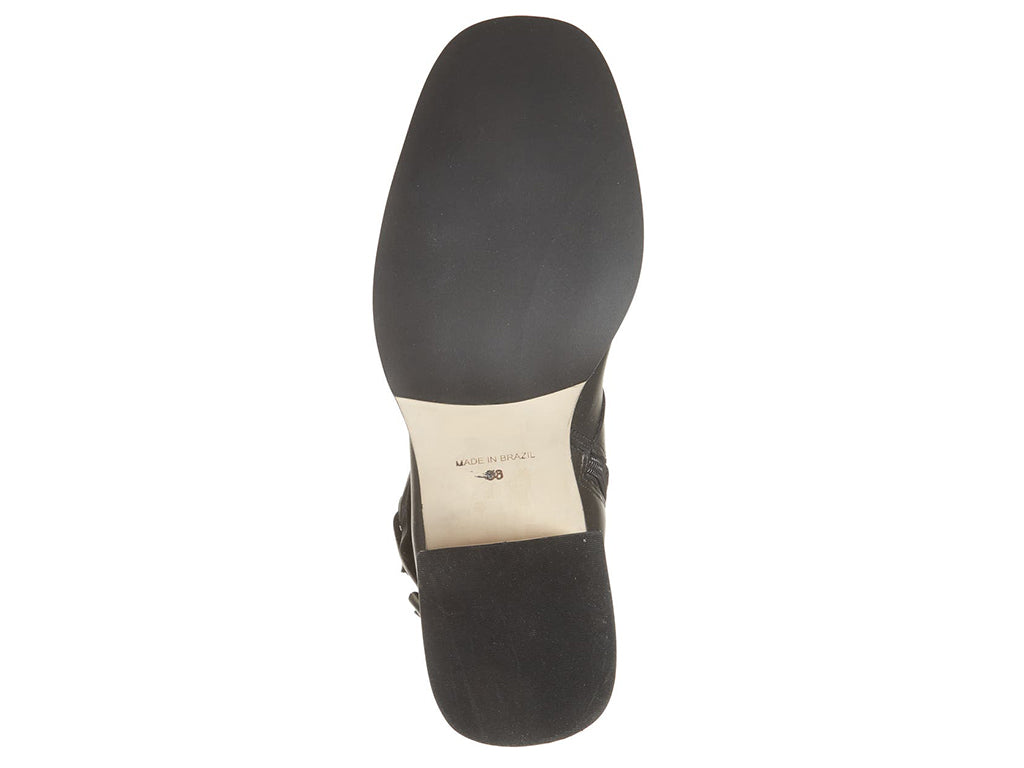 Black ankle boot with silver buckle and criss cross strap design on a white background bottom sole view