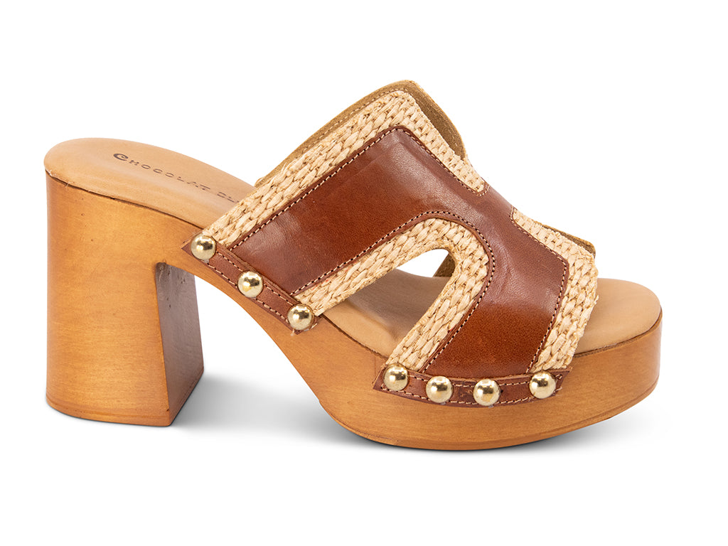 brown slide sandal on a high wooden platform with raffia and brown leather upper - side view