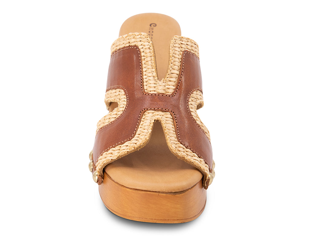 brown slide sandal on a high wooden platform with raffia and brown leather upper - view from the front of the shoe