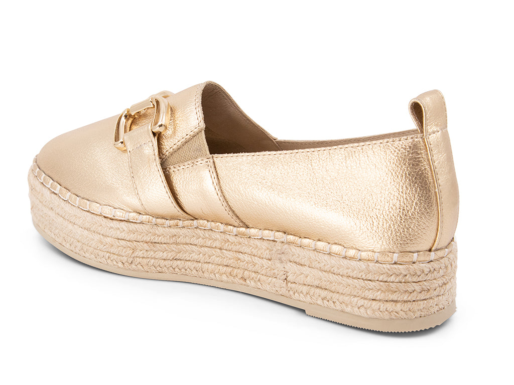 gold espadrille flat shoe with a gold buckle - back view