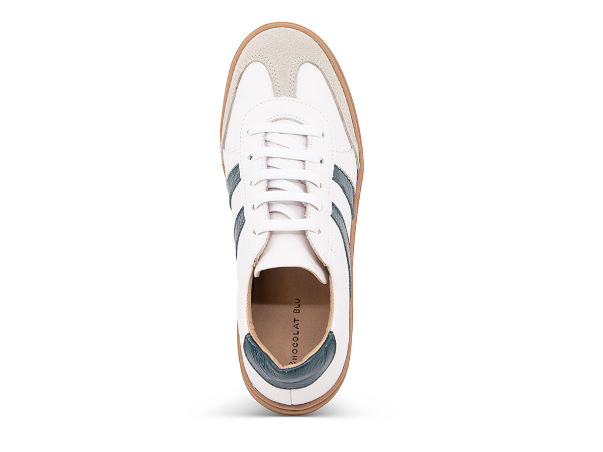 White lace up sneaker with a brown sole and green  stripe on a white background top view