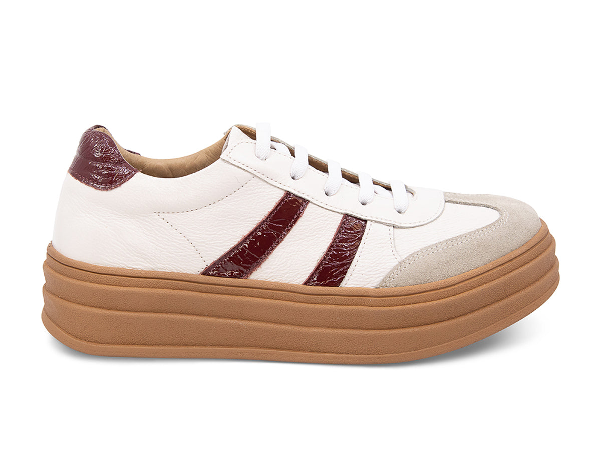 White lace up sneaker with a brown sole and burgundy stripe on a white background side view