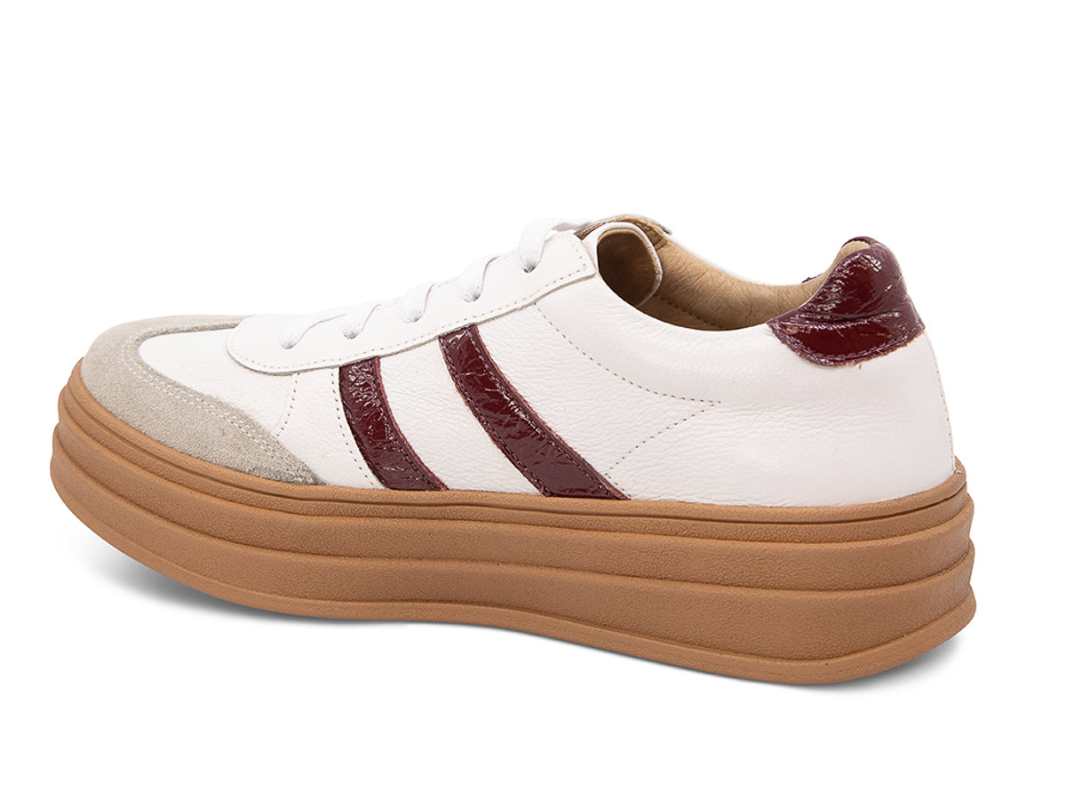 White lace up sneaker with a brown sole and burgundy stripe on a white background side angle view