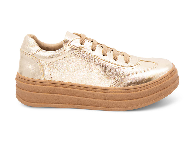 Gold lace up sneaker with a thick platform sole on a white background side view 
