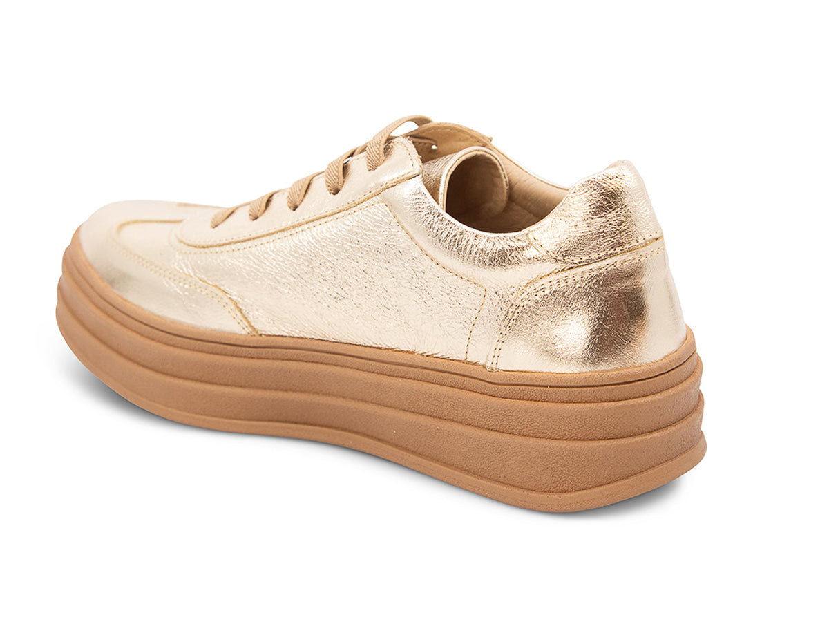 Gold lace up sneaker with a thick platform sole on a white background side angle view 