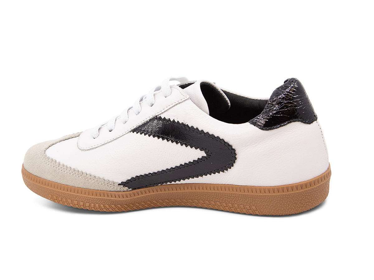 White sneaker with brown sole and black decorative design on a white background side angle view