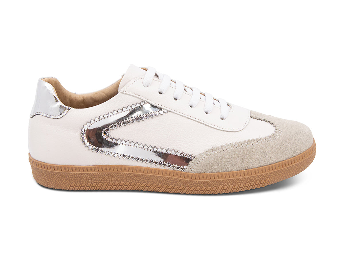 White sneaker with brown sole and silver decorative design on a white background side view