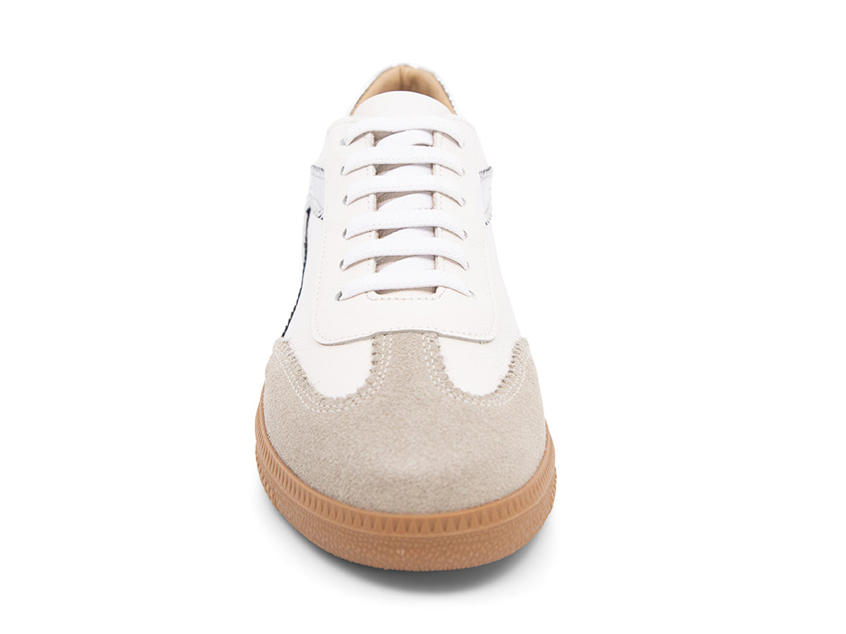 White sneaker with brown sole and silver decorative design on a white background front view
