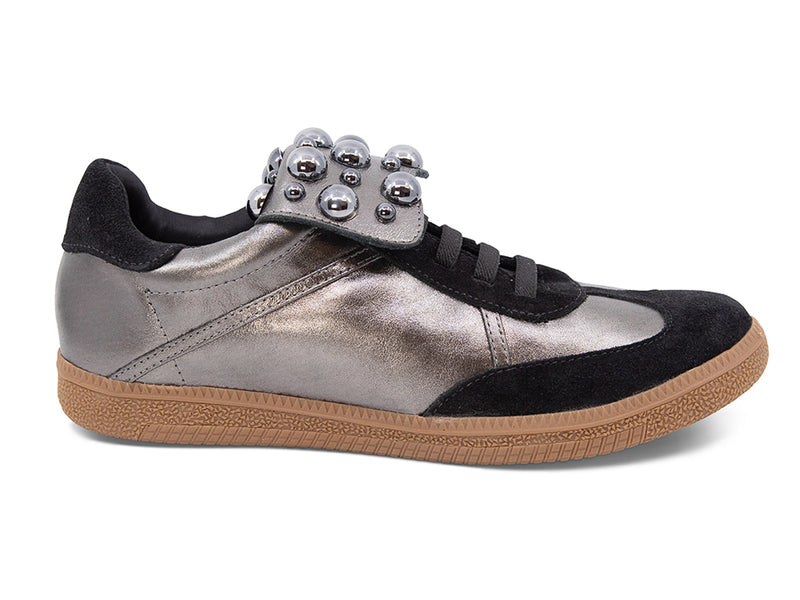 Silver and black sneaker with decorative stud embellishments and brown sole on a white background side view