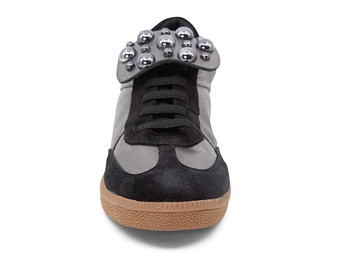 Silver and black sneaker with decorative stud embellishments and brown sole on a white background front view
