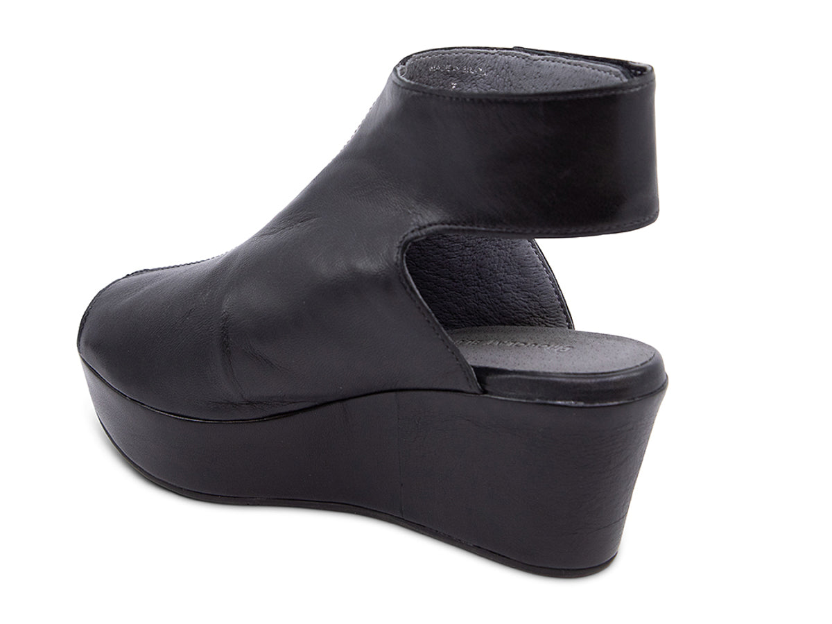 Black leather slide in peep toe wedge platform shoe with ankle velcro strap  on a white background side angle view