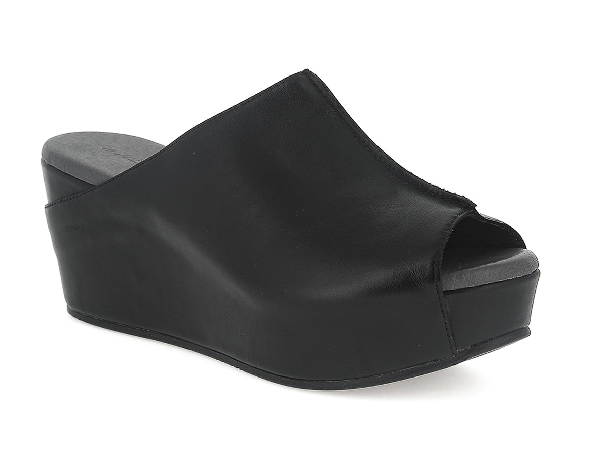 Black leather slide in peep toe wedge platform shoe with exposed seam on upper design on a white background side angle view