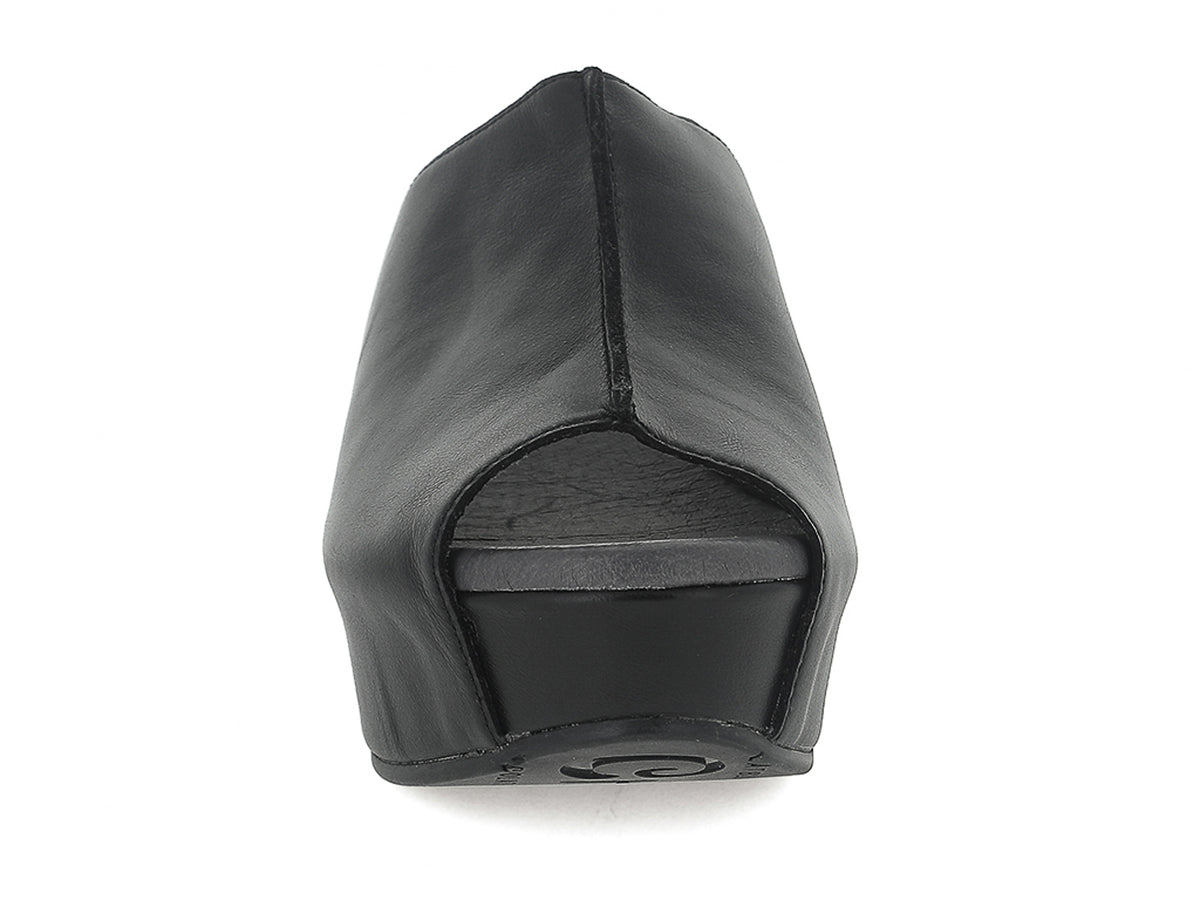 Black leather slide in peep toe wedge platform shoe with exposed seam on upper design on a white background front view