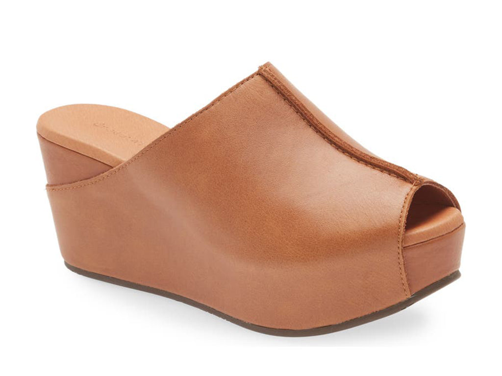 Cognac leather  slide in peep toe wedge platform shoe with exposed seam on upper design on a white background side angle view